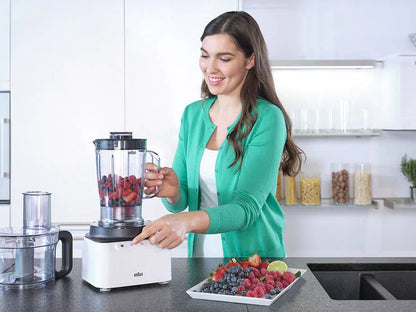 Woman using Braun FP 3131 WH food processor with blender jug and food processor bowl on kitchen counter