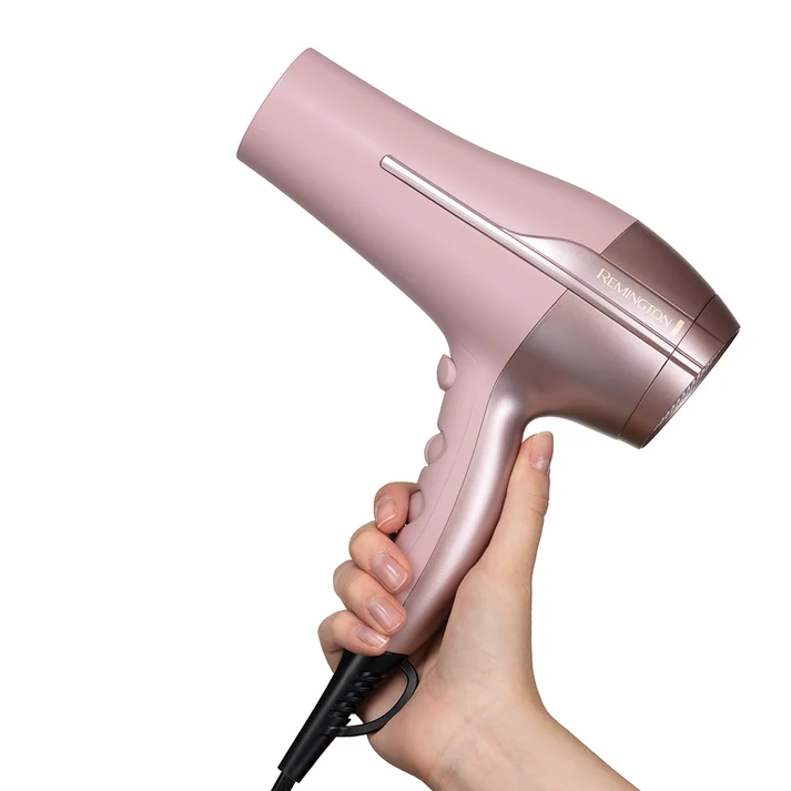 Remington Coconut Smooth pink hair dryer held in hand